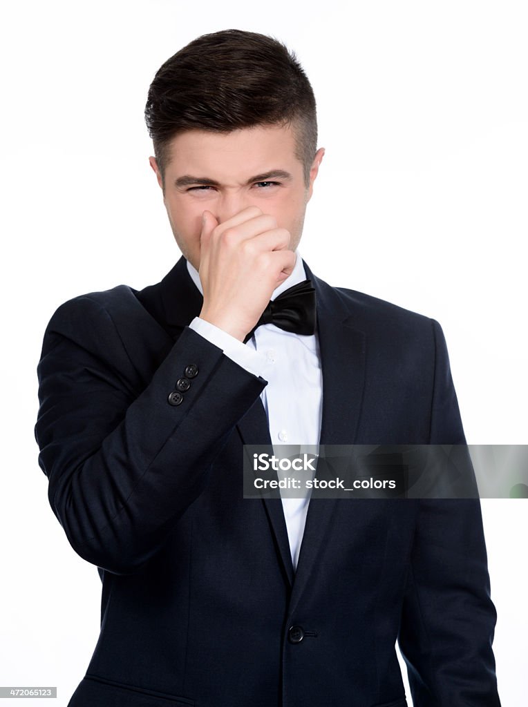 stinky smell businessman frowning and holding fingers on nose. 20-29 Years Stock Photo