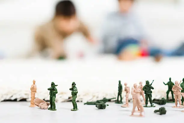 Photo of Group of miniature toy soldiers with children in background