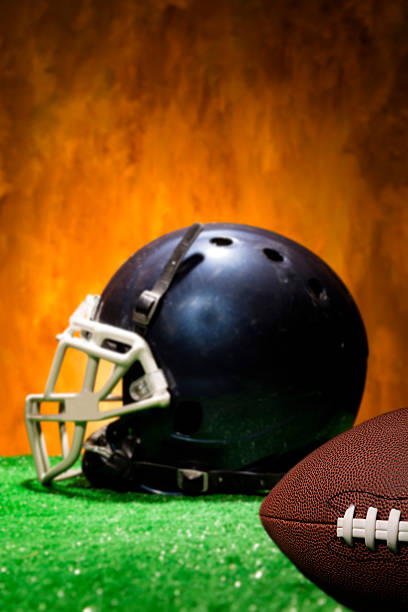 istock Sports:  Football helmet, ball on artificial turf. 472067345