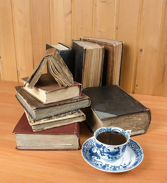 velhos livros e uma xícara de café sobre um de madeira - ретро imagens e fotografias de stock
