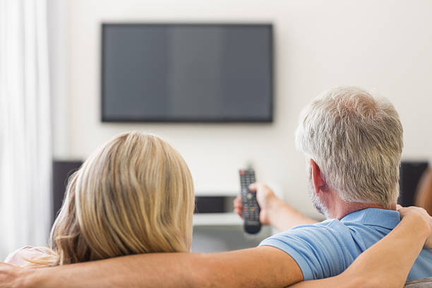 istock Mature couple turning on television 472070281