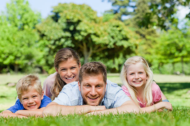istock Smiling family lying down in a park 472070379