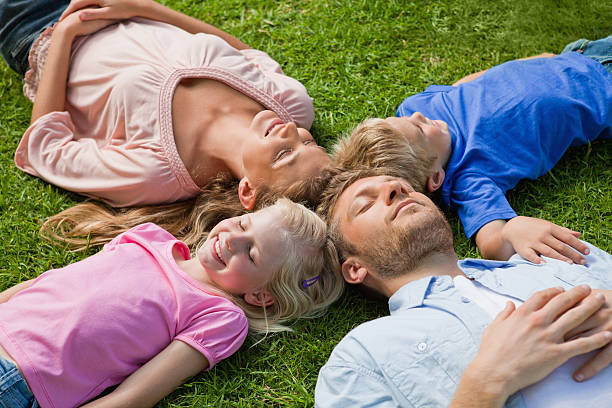 istock Relaxed family lying on the grass 472070523