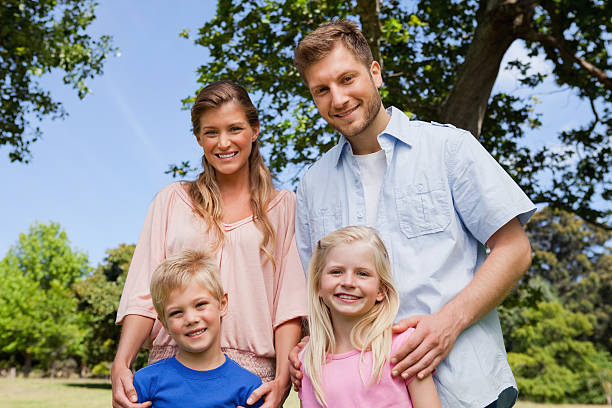 istock Happy family standing in a park together 472070631