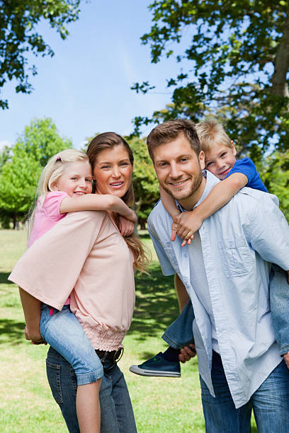 istock Smiling parents looking at the camera while giving their childre 472070705