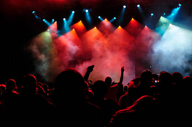istock Brightly colored spotlights over crowd at a concert 472070727