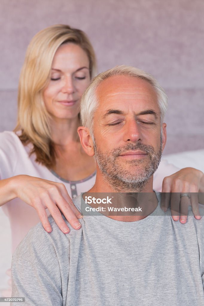 Donna dando un massaggio al marito Sorridere - Foto stock royalty-free di Accudire