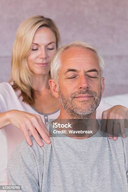 Donna Dando Un Massaggio Al Marito Sorridere - Fotografie stock e altre immagini di Accudire - Accudire, Adulto, Adulto di mezza età