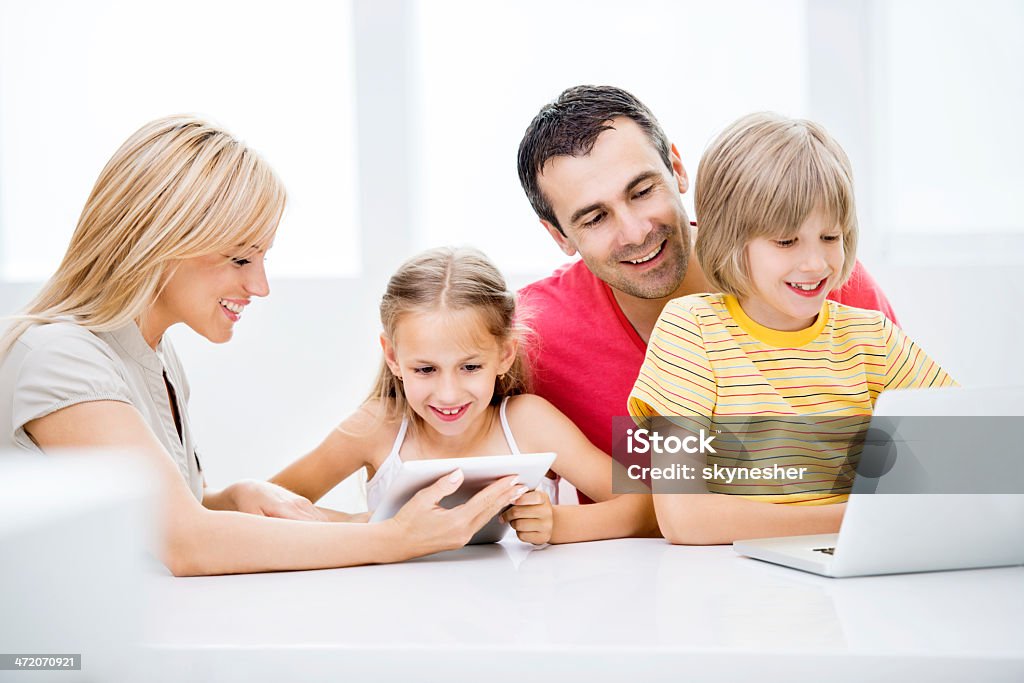 Famille à l'aide de la technologie sans fil. - Photo de Adulte libre de droits