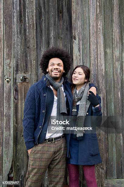 Young Couple Against A Wooden Background Stock Photo - Download Image Now - 20-29 Years, 25-29 Years, 30-34 Years