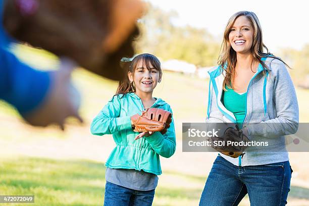 Madre E Hija Disfrutando De Béisbol Con Dad En El Parque Foto de stock y más banco de imágenes de Béisbol