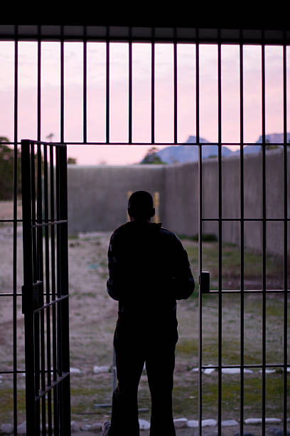 Man Leaving Prison Robben Island, South Africa - August 3, 2008: A silhouette of a man leaving the prison on Robben Island near Cape Town, South Africa on August 3, 2008. prison lockdown stock pictures, royalty-free photos & images