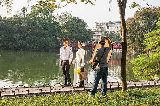 Hanoi, Vietnam - October 20, 2013: Lakeside photoshoot of couple getting married on path beside Lake Hoan Kiem, Hanoi, Vietham.