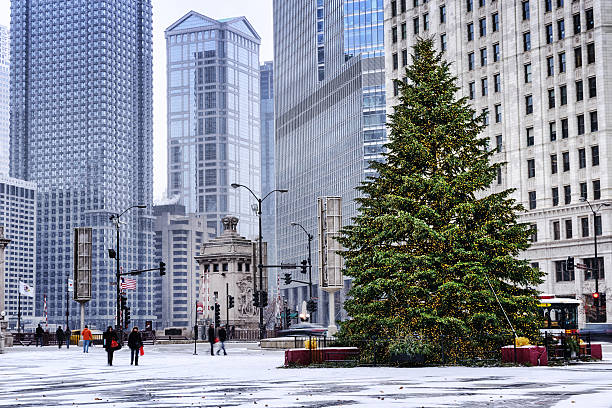 Christmas tree in Chicago snowstorm Chicago, USA - December 8, 2013: Christmas tree at Pioneer Court in a snowstorm, downtown Chicago in December. Michigan Avenue and  Bridgehouse in the background. RR Donnelley Building in distant background. Winter scene with background people. editorial architecture famous place local landmark stock pictures, royalty-free photos & images