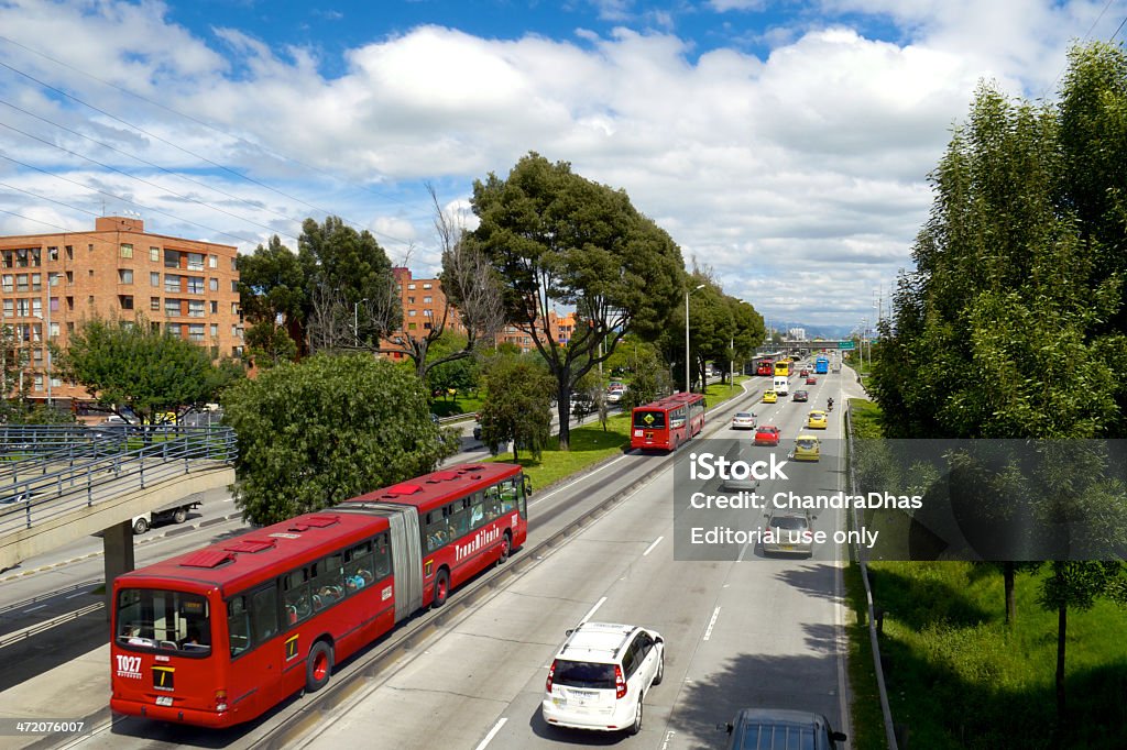 Bogota Colombia: The Autopista Norte, A Major Urban Arterial Highway In The Andean Capital City Bogota, Colombia - December 05, 2013:  Looking to the North of the capital city of Bogota in Colombia, South America, at the northbound carriageway of the Autopista Norte.  To the left of the photo isa TransMilenio articulated bus; they have their own lanes on the carriageway reserved solely for their own use.  The other lanes carry normal traffic.  Some apartment buildings in red brick can also be seen.  In the far background a TransMilenio station is visible. Transmilenio Stock Photo