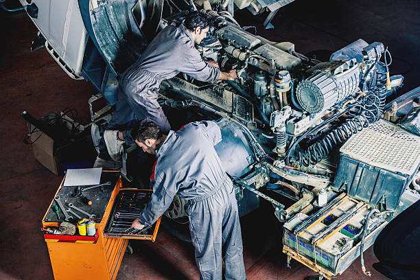 Mechanics working on a truck Auto and trucks mechanics working on a truck. car mechanic top view stock pictures, royalty-free photos & images