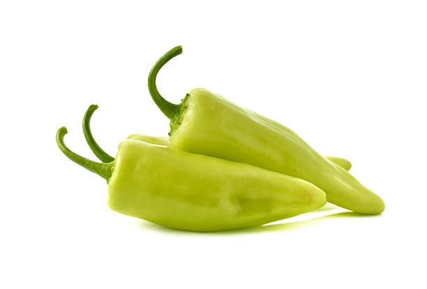 Green chili peppers with stems on white background