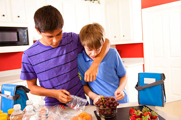 relations: adopte brothers en cuisine faire des déjeuners. - adoption early teens teenager family photos et images de collection