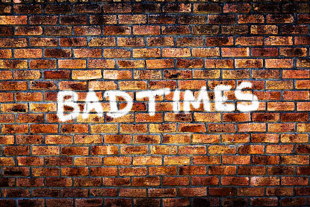 istock Bad Times says depressing graffiti on rough brick wall 472077315