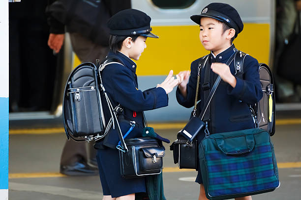 Tokyo, Japan - November 22 2013: Unidentified little Japanese students wait for a train to school in the morning at Tokyo station