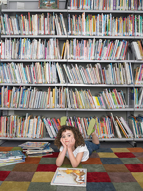 istock Girl Lying On Floor With Storybook In Library 472079679