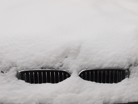 Zurich, Switzerland - December 3, 2010: After heavy snowfall, the hood of a BMW car that is parked on a street in Zurich is covered with lots of snow.