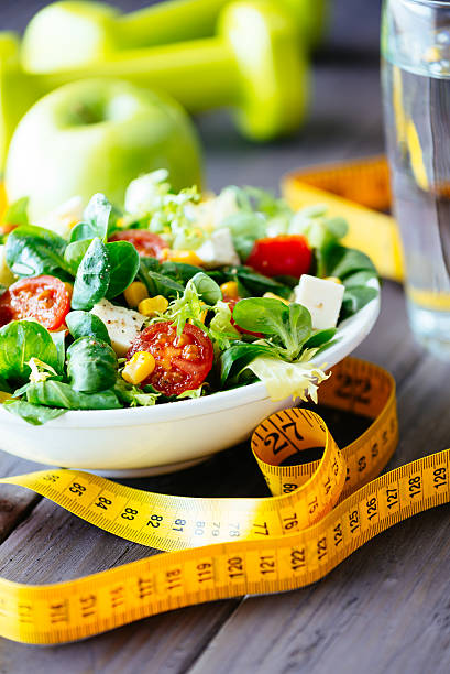 salada saudável para ginástica de estilo de vida - dieting healthy eating healthy lifestyle tape measure - fotografias e filmes do acervo