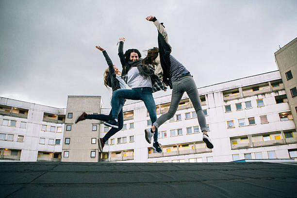 istock Friends jumping high in front of urban background 472082246