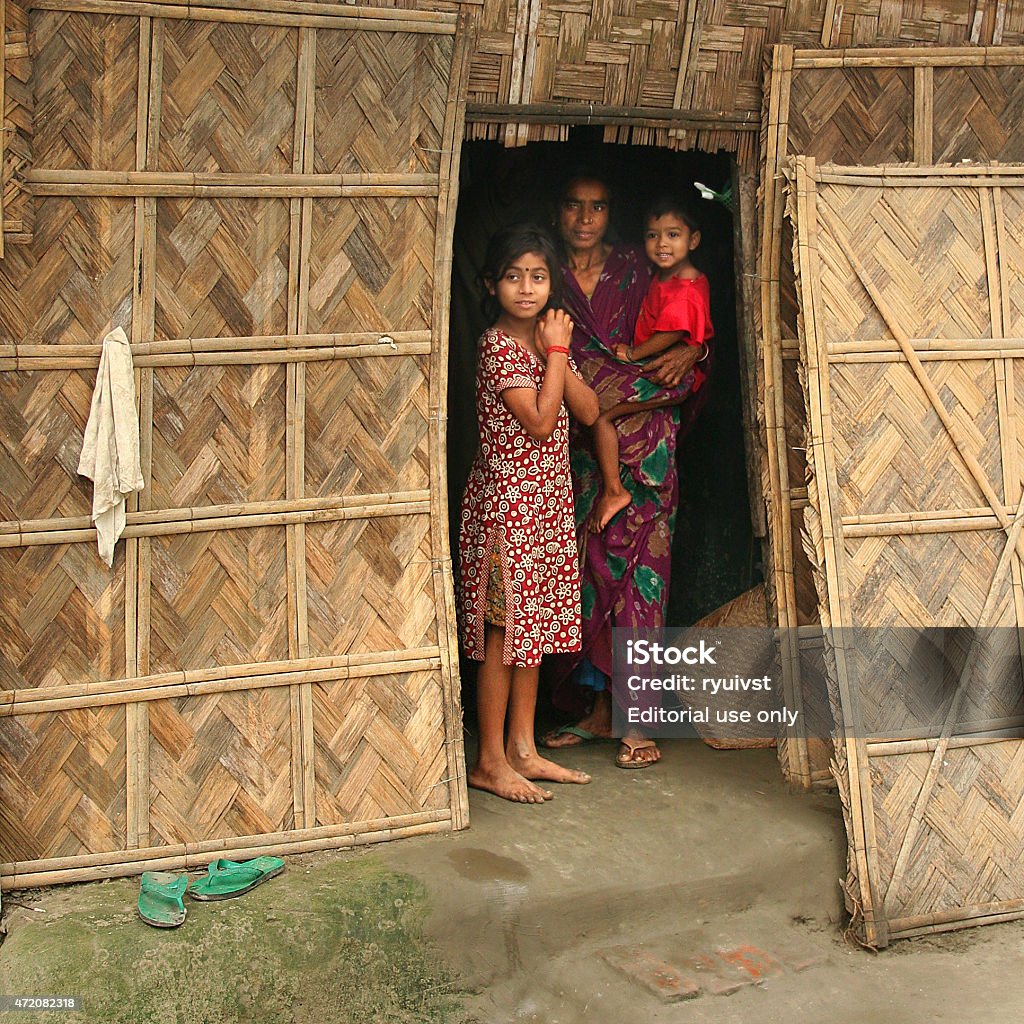 Bamboo Home Lohajang, Bangladesh - February 9, 2008: Mother with two kids on the entrance of their bamboo home in Lohajang, Bangladesh Bangladesh Stock Photo