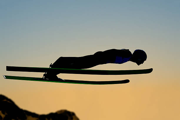 istock Silhouette of ski jumper flying at sunset 472082371