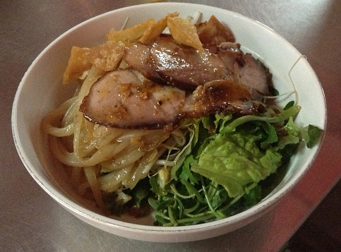 Bowl of broth, smoked noodles, herbs, salad greens, pork and crispy noodles. Vietnamese specialty. (Hoi An, Viet Nam)