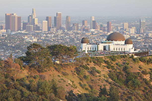 Los Angeles Skyline + Observatory Griffith Observatory located on the slopes of Griffith Park’s Mount Hollywood has a great view of Downtown Los Angeles - one of the largest urban skylines in the country. The skyscrapers are all modern since the city did not permit any structures taller than the 27-story City Hall until 1958. griffith park observatory stock pictures, royalty-free photos & images