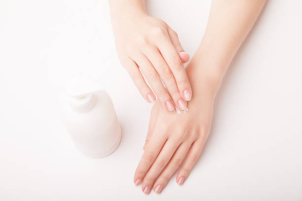 istock Beautiful female hand applying cream 472086601
