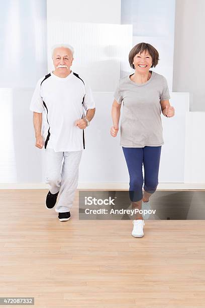 Senior Couple Jogging At Gym Stock Photo - Download Image Now - 2015, Active Lifestyle, Active Seniors