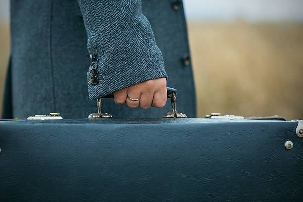 istock man in woolen overcoat holds an old suitcase 472087382