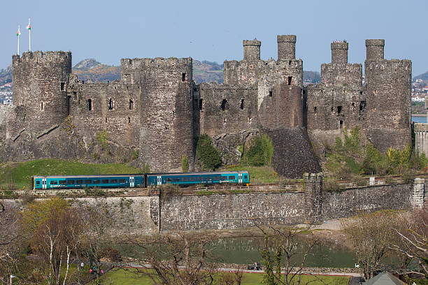 château de conwy et un train de passagers, - conwy castle train travel people traveling photos et images de collection