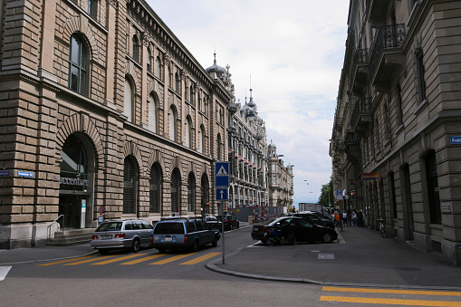 Zurich, Switzerland - June 9, 2007: People and cars move along the street and sidewalks between some of the buildings in Zurich's financial district.