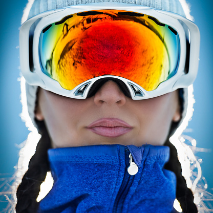 Close up shot of a woman wearing ski goggles.