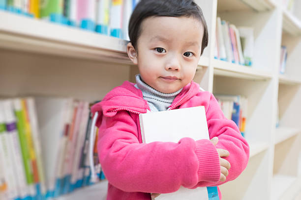 istock Cute asia children in the library 472093443