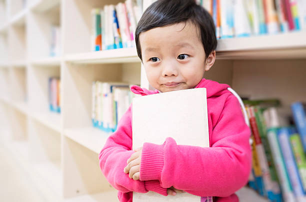 istock Cute asia children in the library 472093449