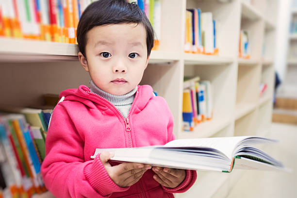 istock Cute asia children in the library 472093457