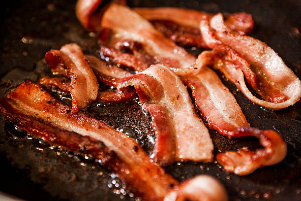 Sizzling Bacon Frying in a Pan stock photo