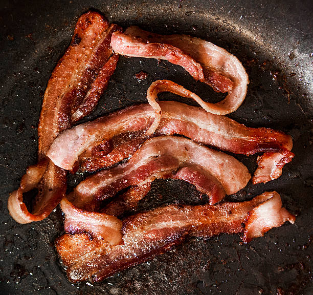 istock Sizzling Bacon Frying in a Pan 472093757
