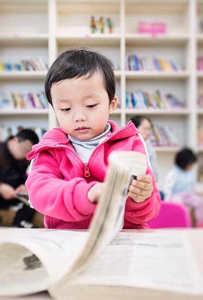 istock Cute asia children in the library 472093861
