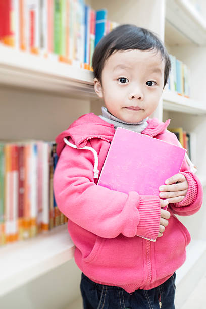istock Cute asia children in the library 472093869