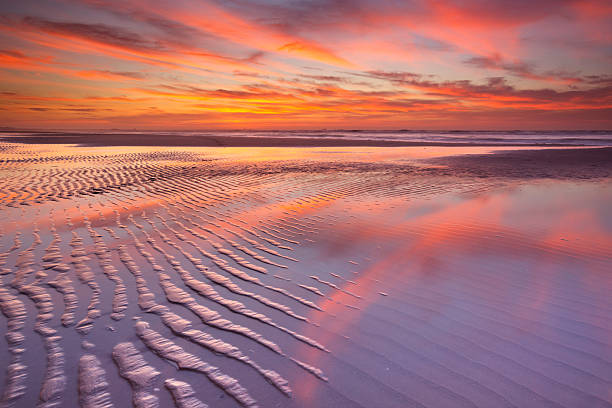 istock Beautiful sunset and reflections on the beach at low tide 472094203