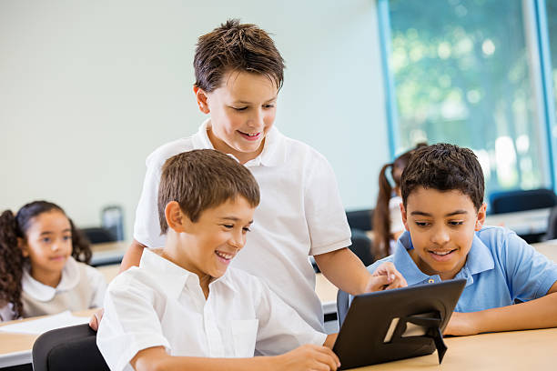 istock Preteen private school boys using digital tablet technology in class 472095203