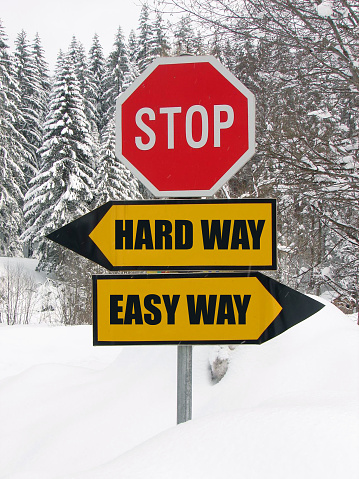 hard and easy way road sign in nature