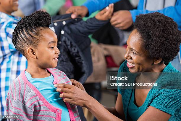 Madre Aiutando Sua Figlia Trovare Capi Di Abbigliamento Invernali Di Unità - Fotografie stock e altre immagini di Afro-americano