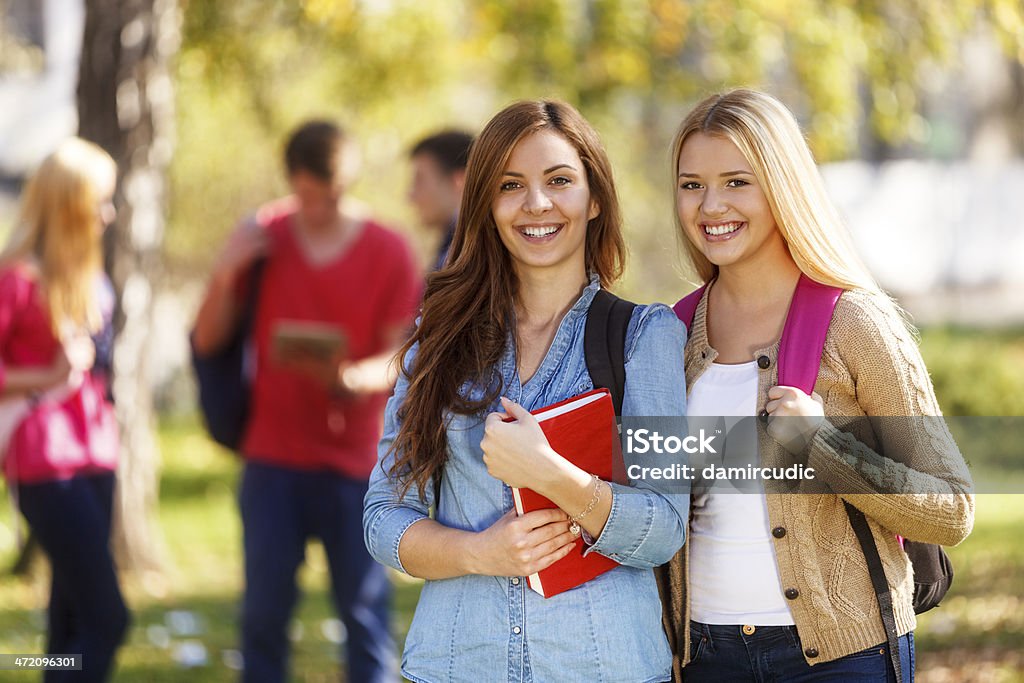 Две Счастливые Студенты в передней части университетских - Стоковые фото Студент роялти-фри